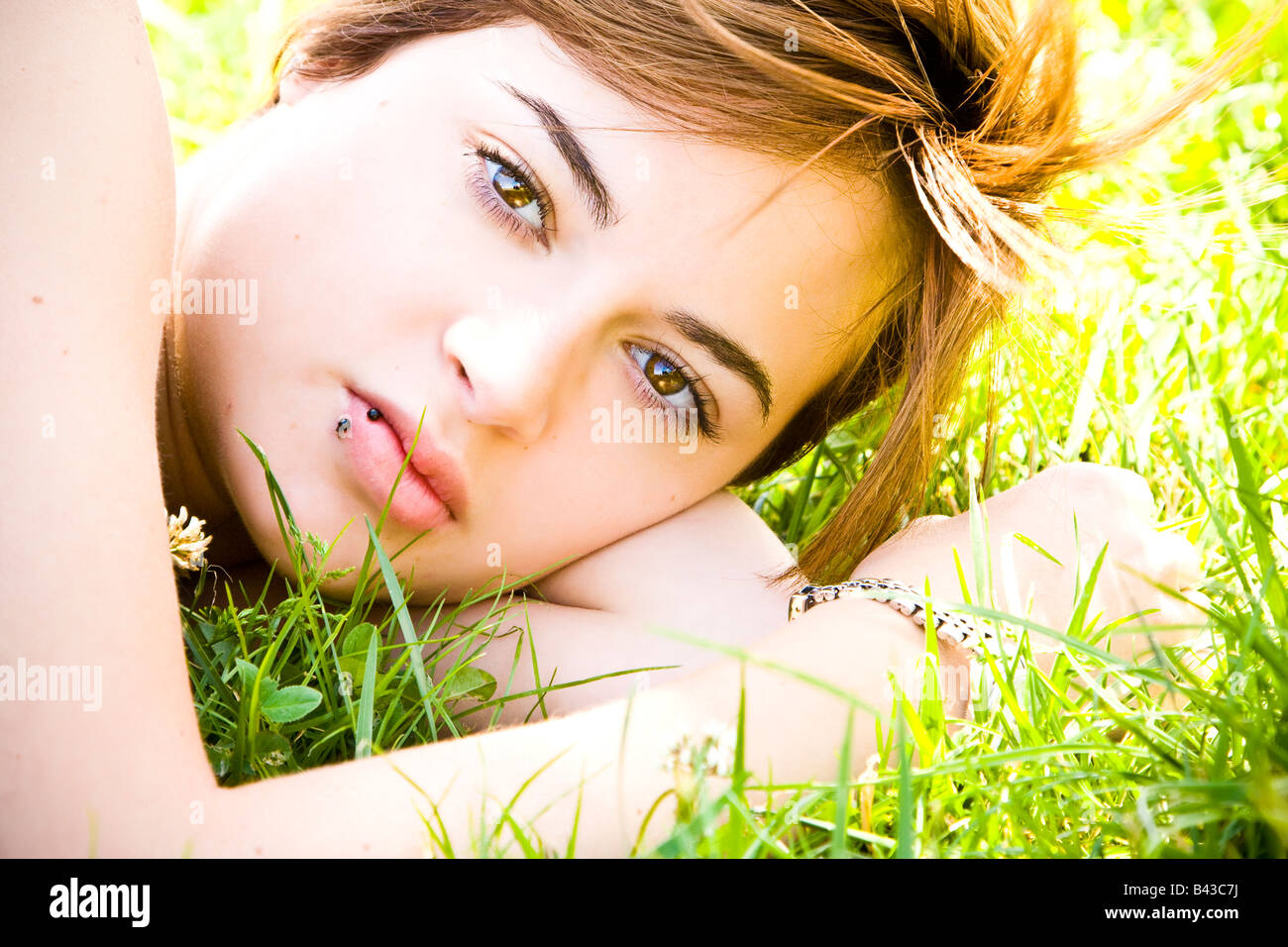Young beautiful blond staring at camera on the grass Stock Photo