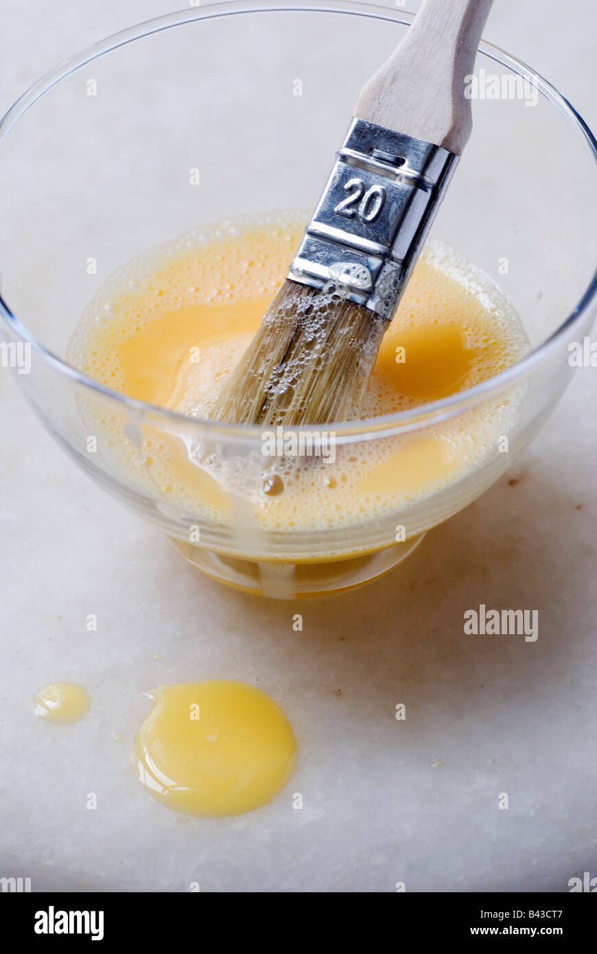 Beaten egg yolk in bowl with brush Stock Photo Alamy