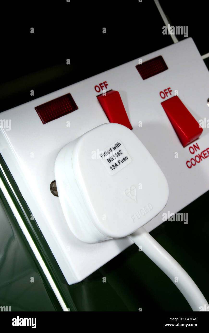 a standard plug in an electrical socket showing the on off wording Stock Photo