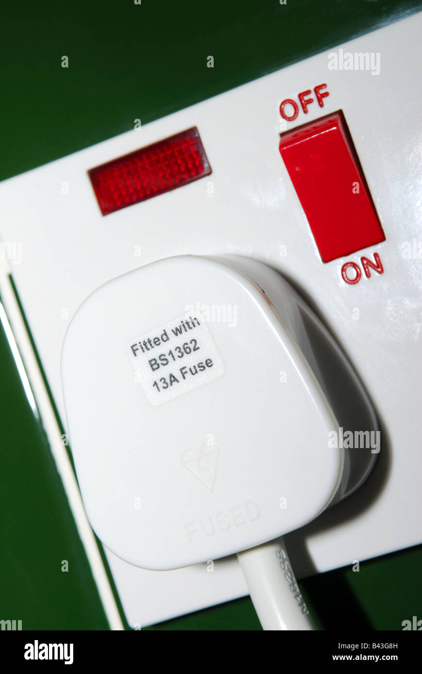 a standard plug in an electrical socket showing the on off wording Stock Photo