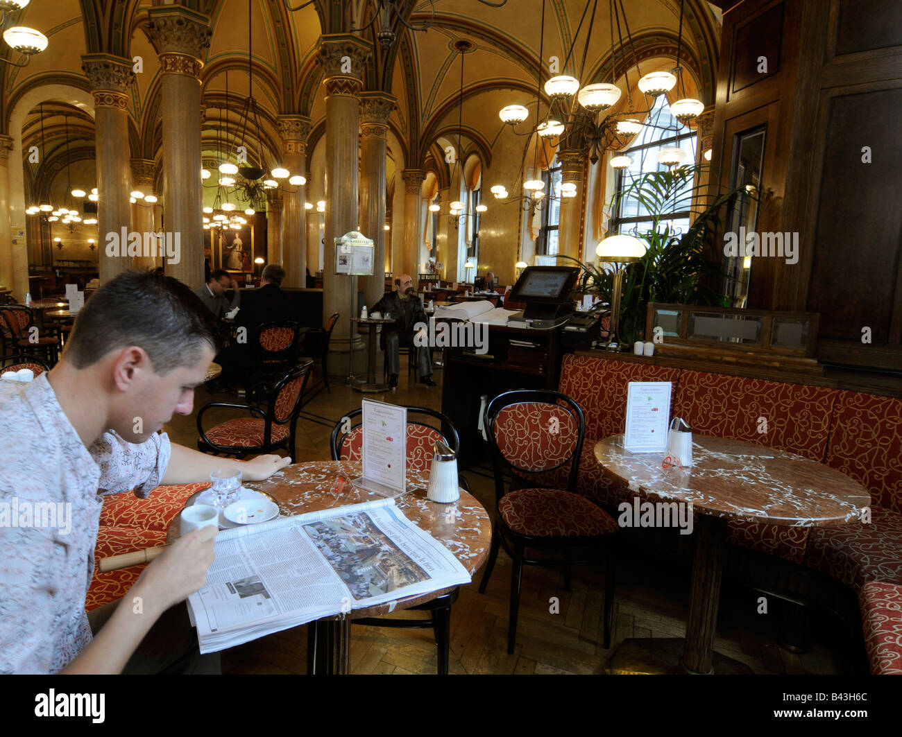 Portrait of a man reading his newspaper while having coffee in the Cafe Central, a landmark coffeehouse in Vienna, Austria Stock Photo