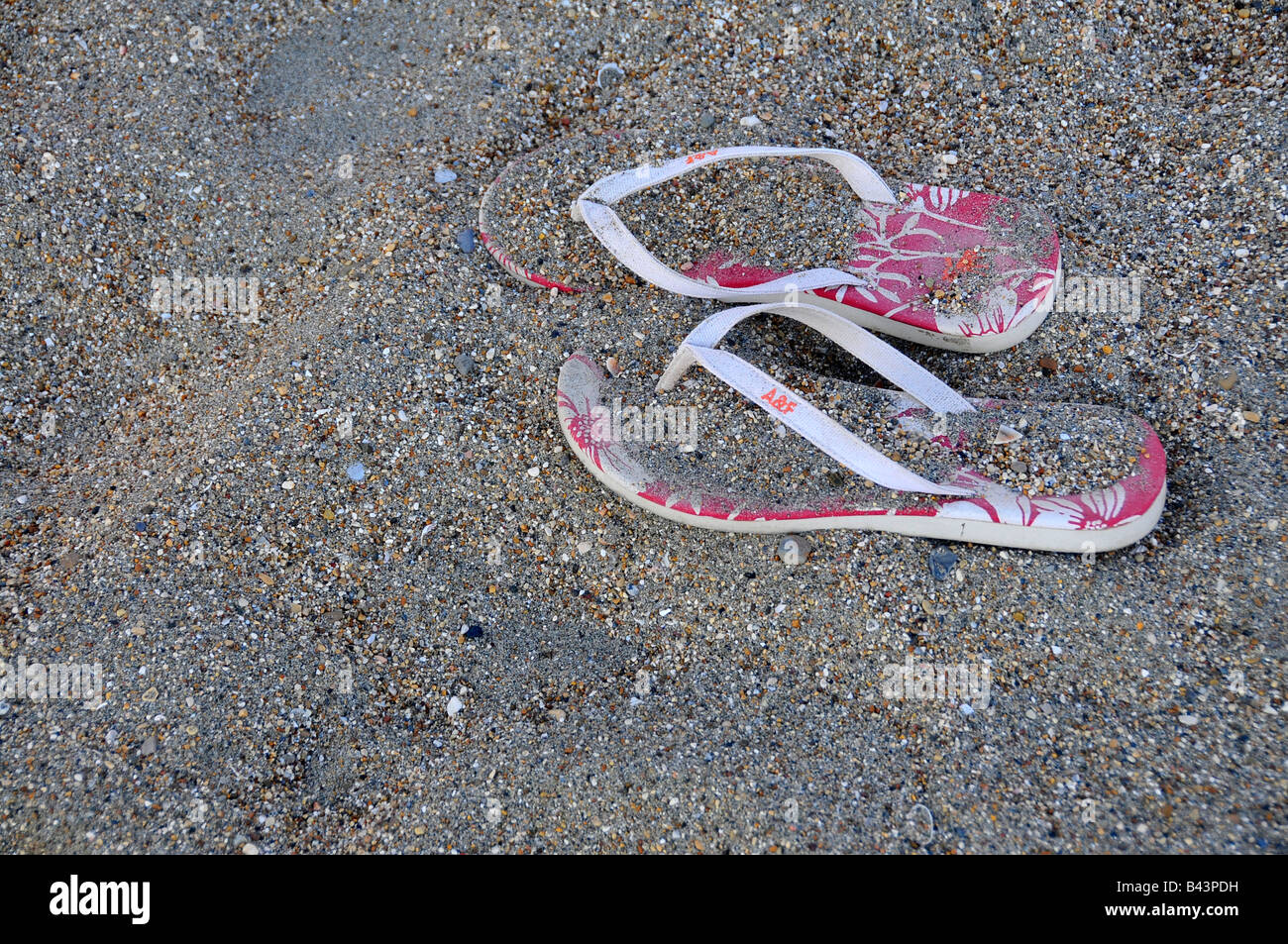 pair of pink flip flops left on the beach Stock Photo - Alamy