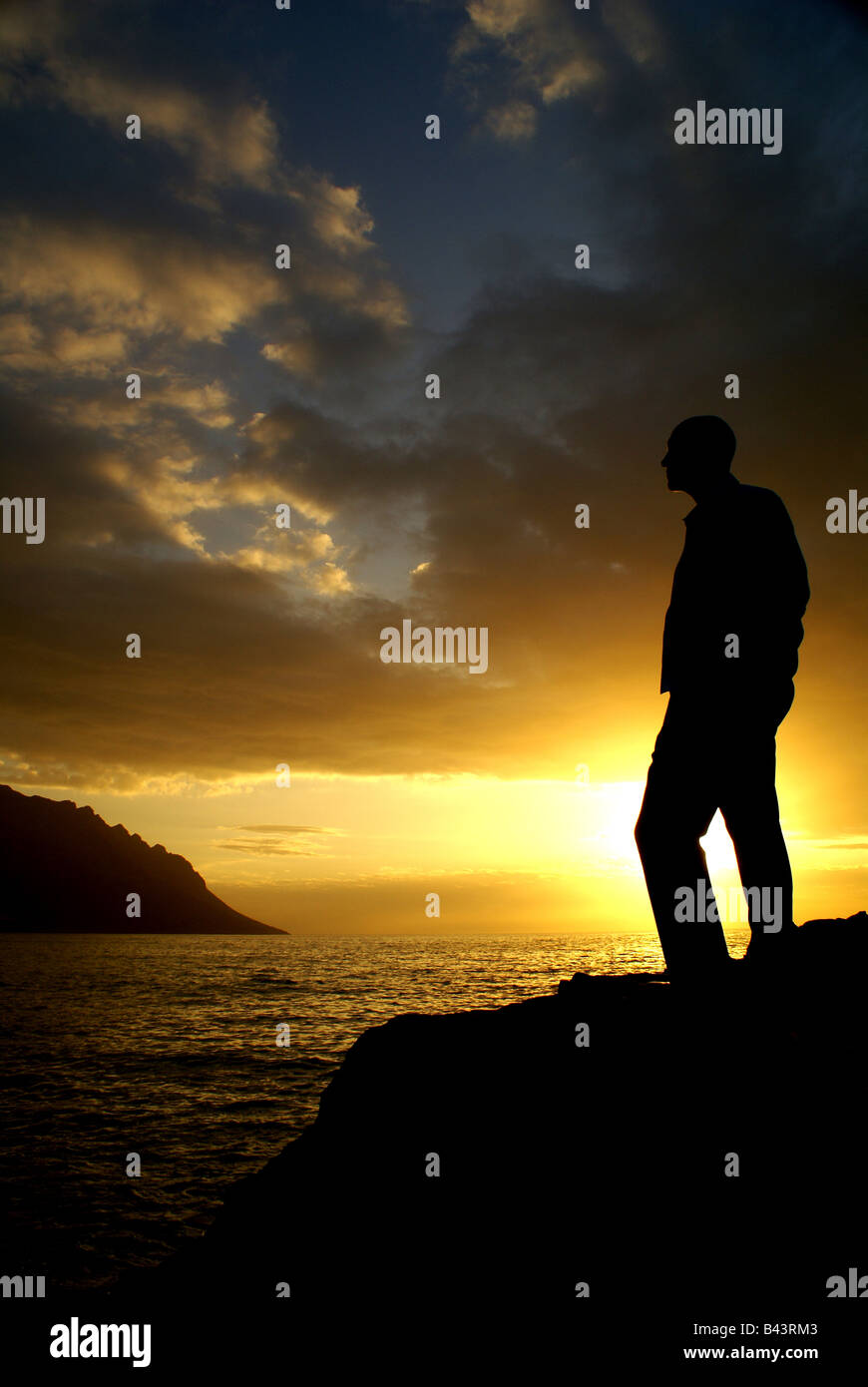 Silhouette of man at sunset by the sea Stock Photo - Alamy