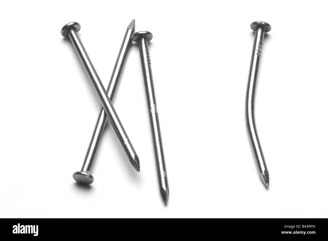 Four (4) common nails, 3 straight and 1 bent, black and white, isolated