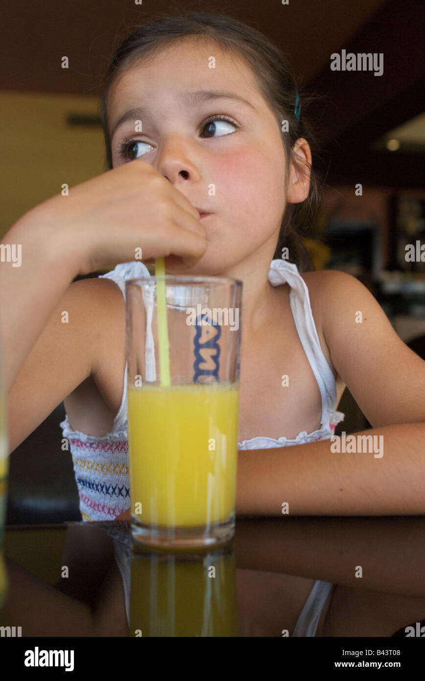 Child drinking orange juice with a straw Stock Photo Alamy