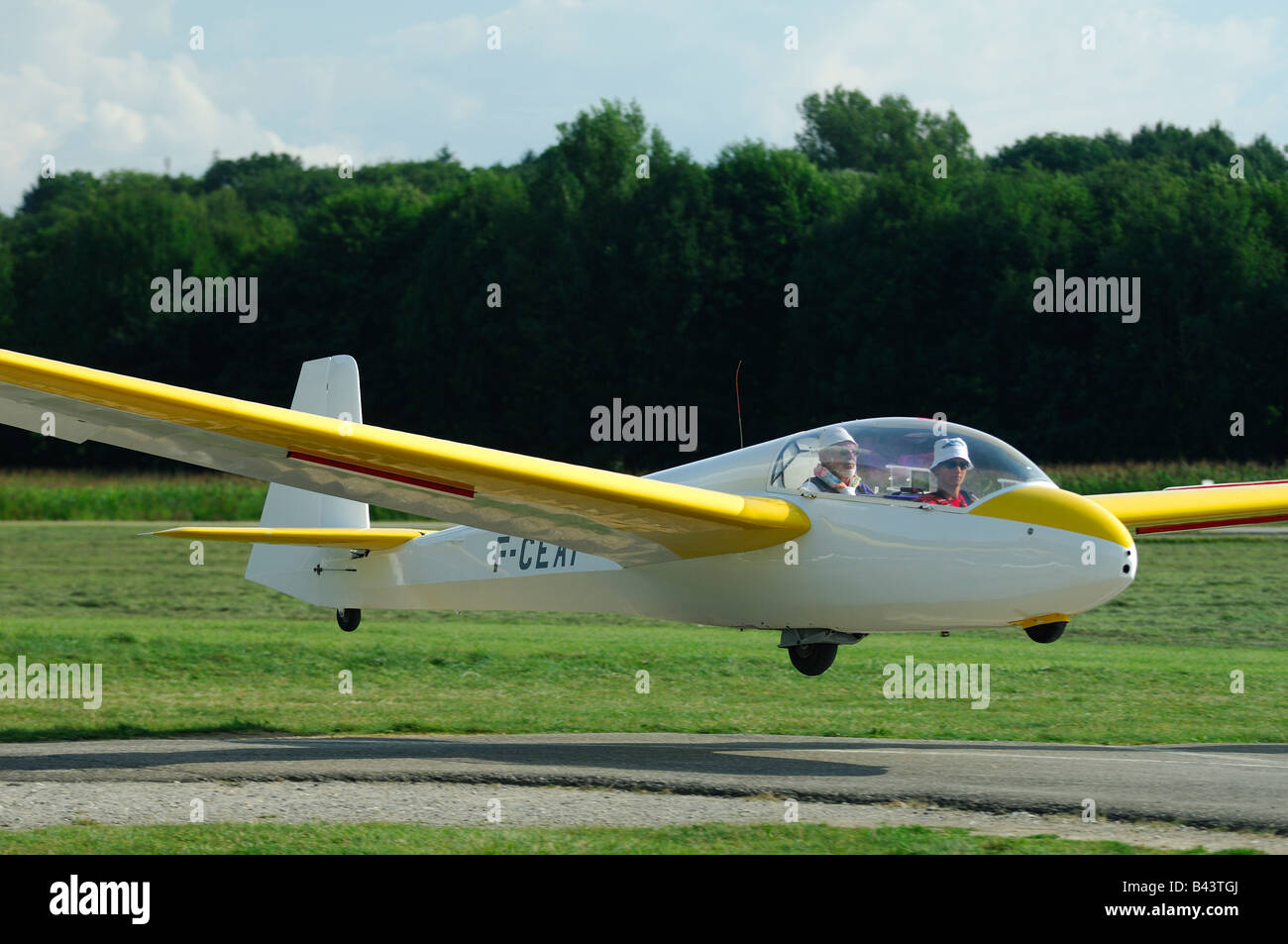 A trainer glider ASK-13 landing on runway airfield - France Stock Photo
