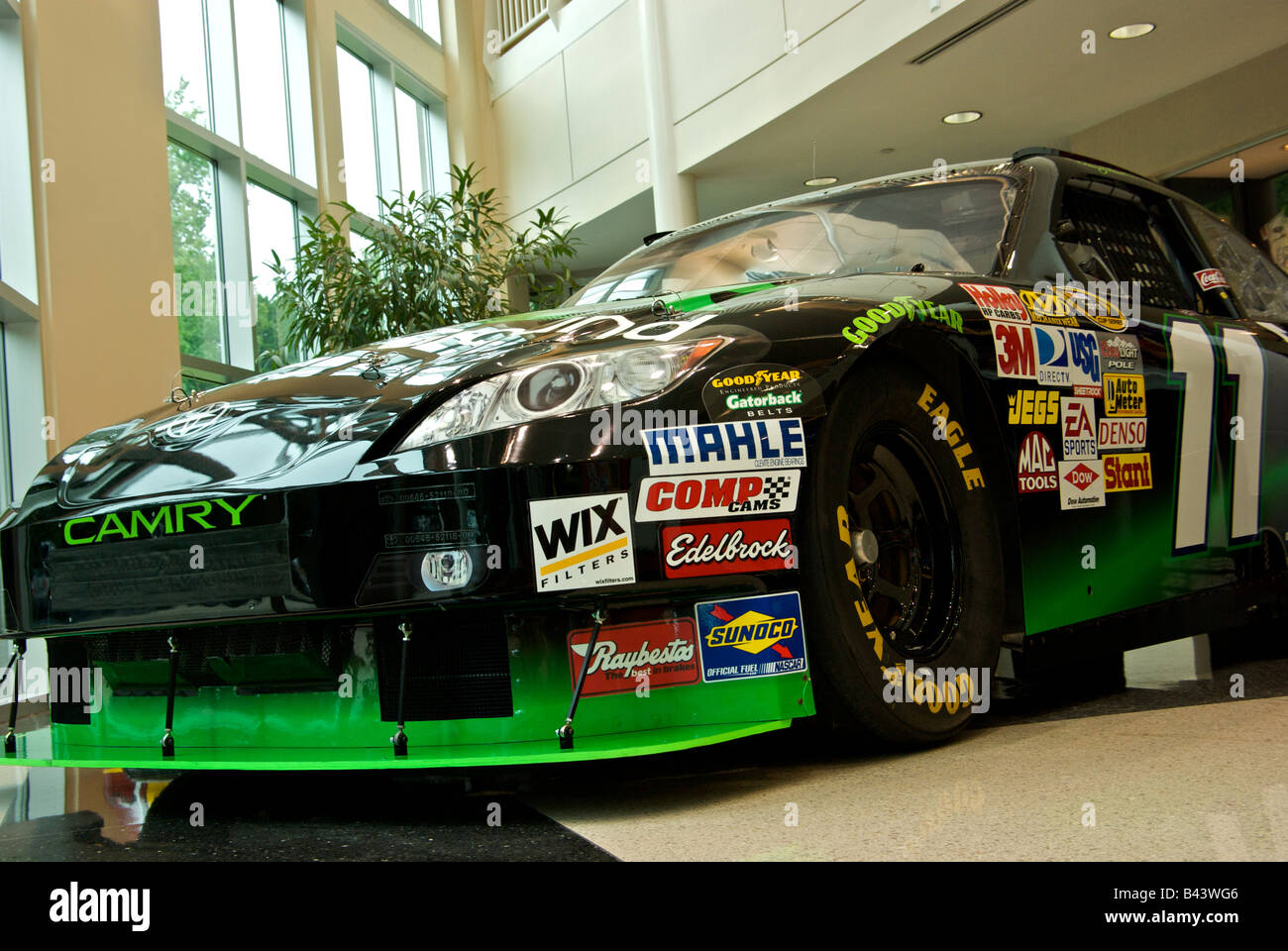 Denny Hamlin's Toyota Camry NASCAR 'car of tomorrow' race car with sponsor decals on display at Joe Gibbs Racing Stock Photo