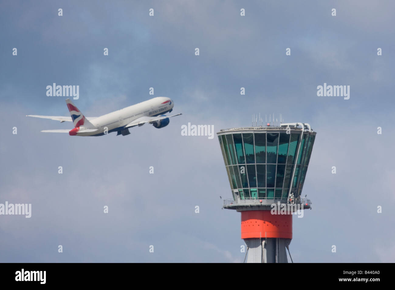 British Airways Boeing 777 taking off in the background of London Heathrow control tower. Stock Photo