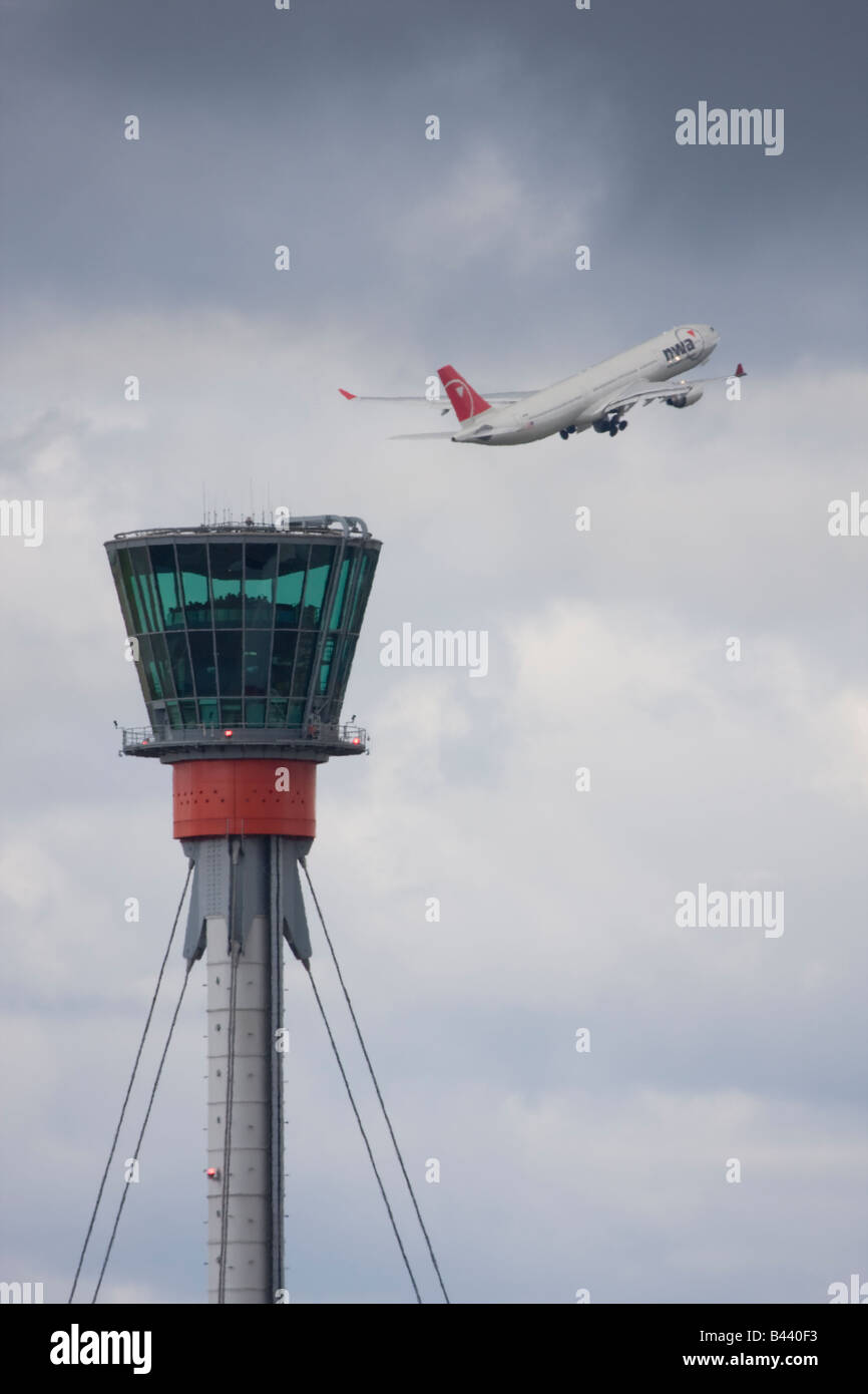 Northwest Airlines Airbus A330 taking off in the background of London Heathrow control tower. Stock Photo