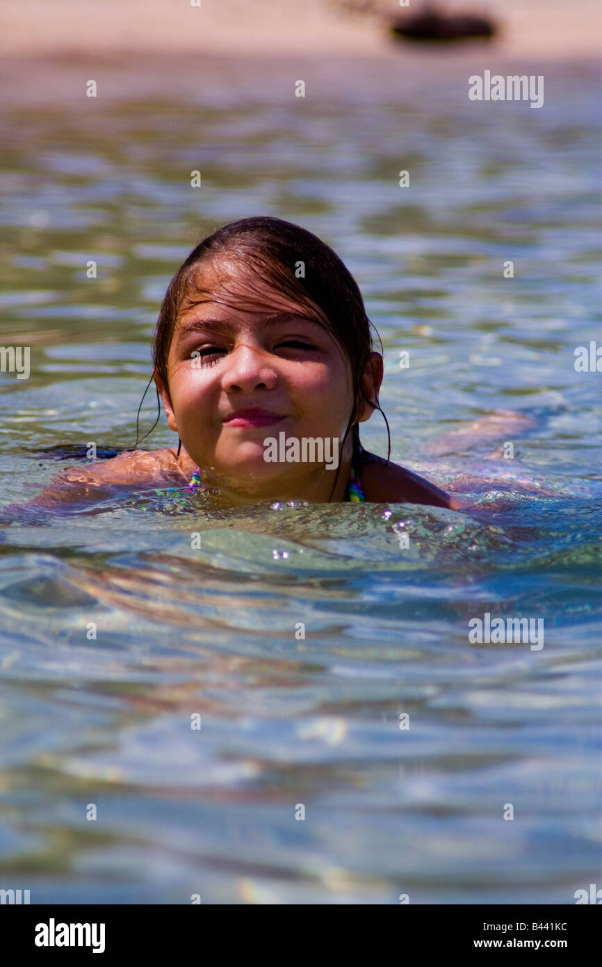 Panama, Isla Grande, Beautiful girl swiming in the crystalline water she smiles enjoying the sunny day of summer Stock Photo