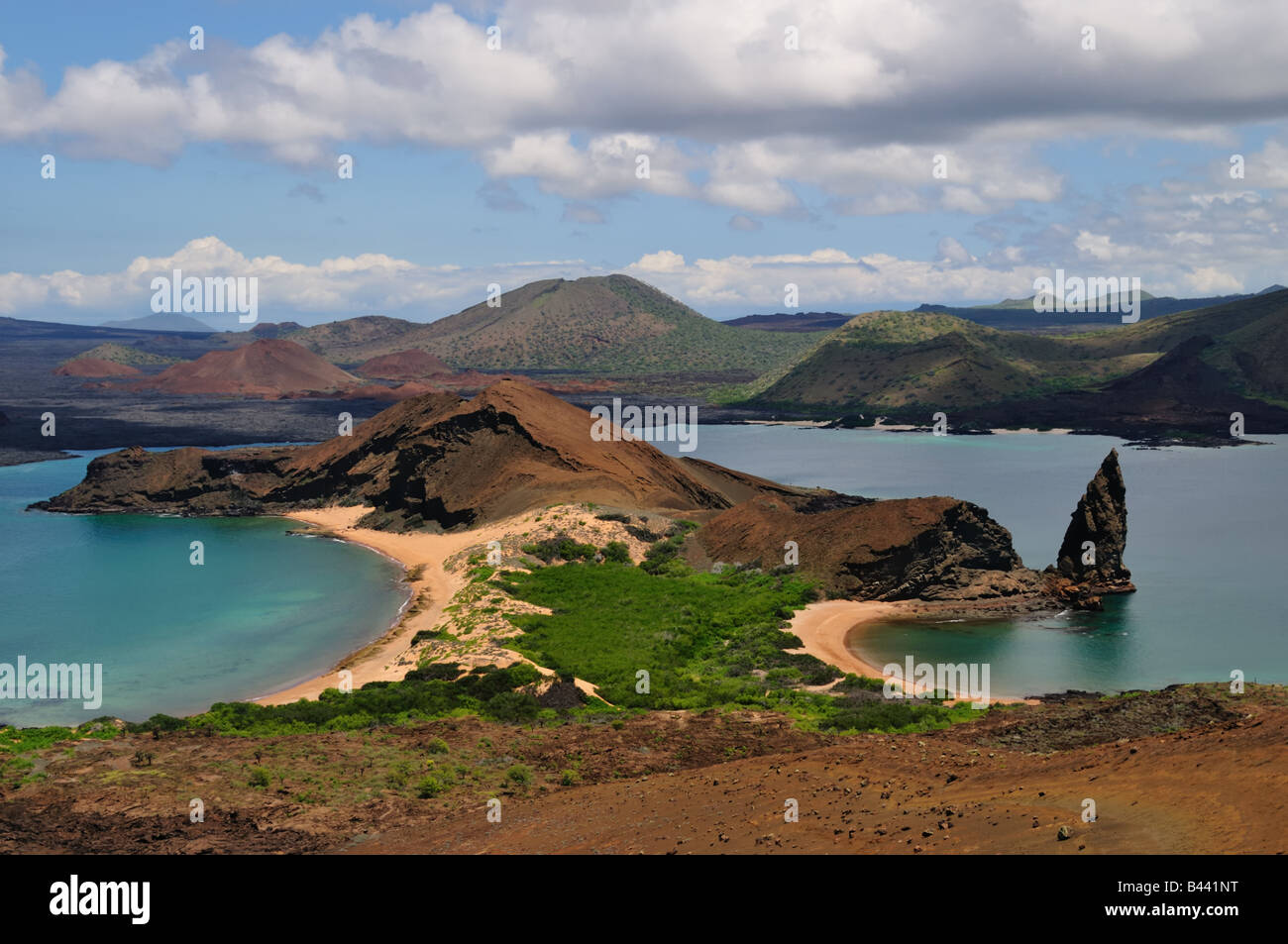 Bartolome Island is home to the famous landmark Pinnacle Rock. The angular rock juts out into tropical blue waters. Stock Photo