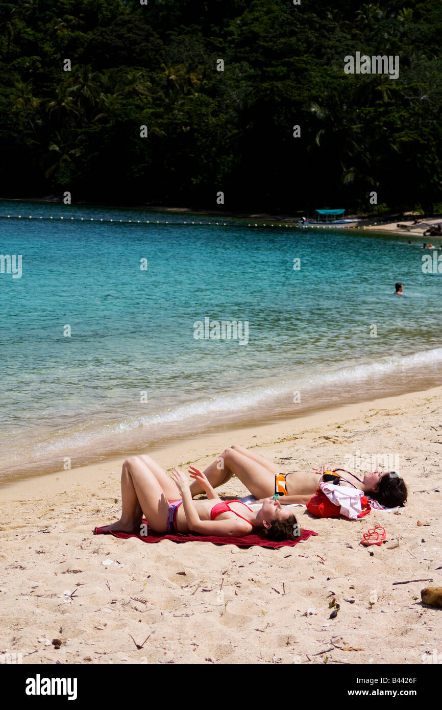 Panama, Isla Grande, Couple of friends gets a sun tan reclined in the sand on the Panamanian Caribbean Stock Photo