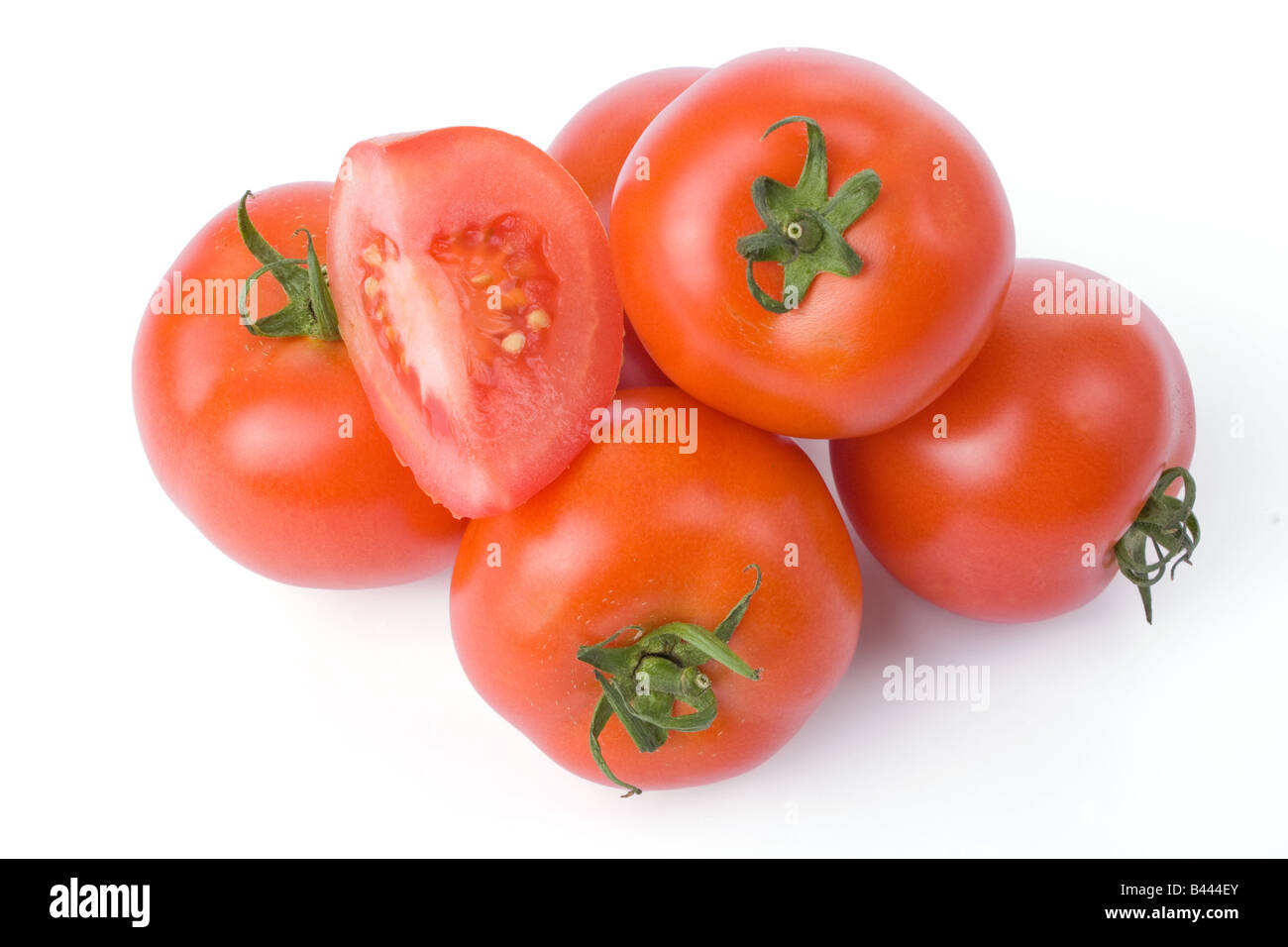 Ripe tomatoes isolated on a white background with one cut in a quarter Stock Photo