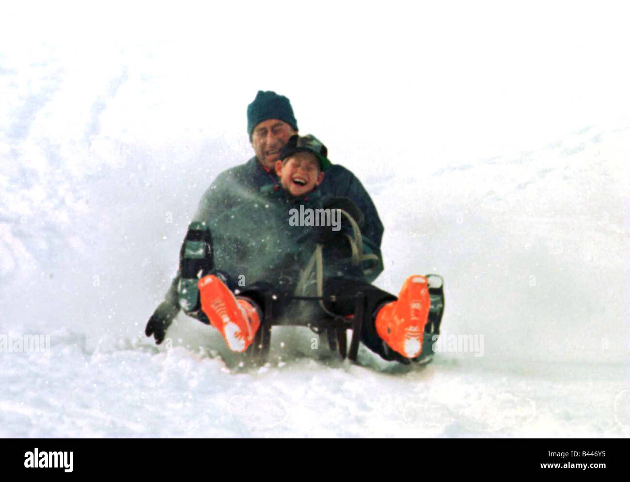 Prince Charles on a sledge with Prince Harry while on holiday in Klosters Switzerland January 1997 Stock Photo