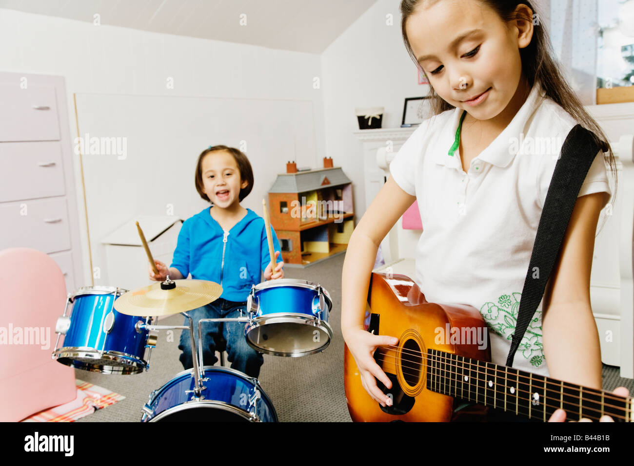 Asian sisters playing drums and guitar Stock Photo Alamy