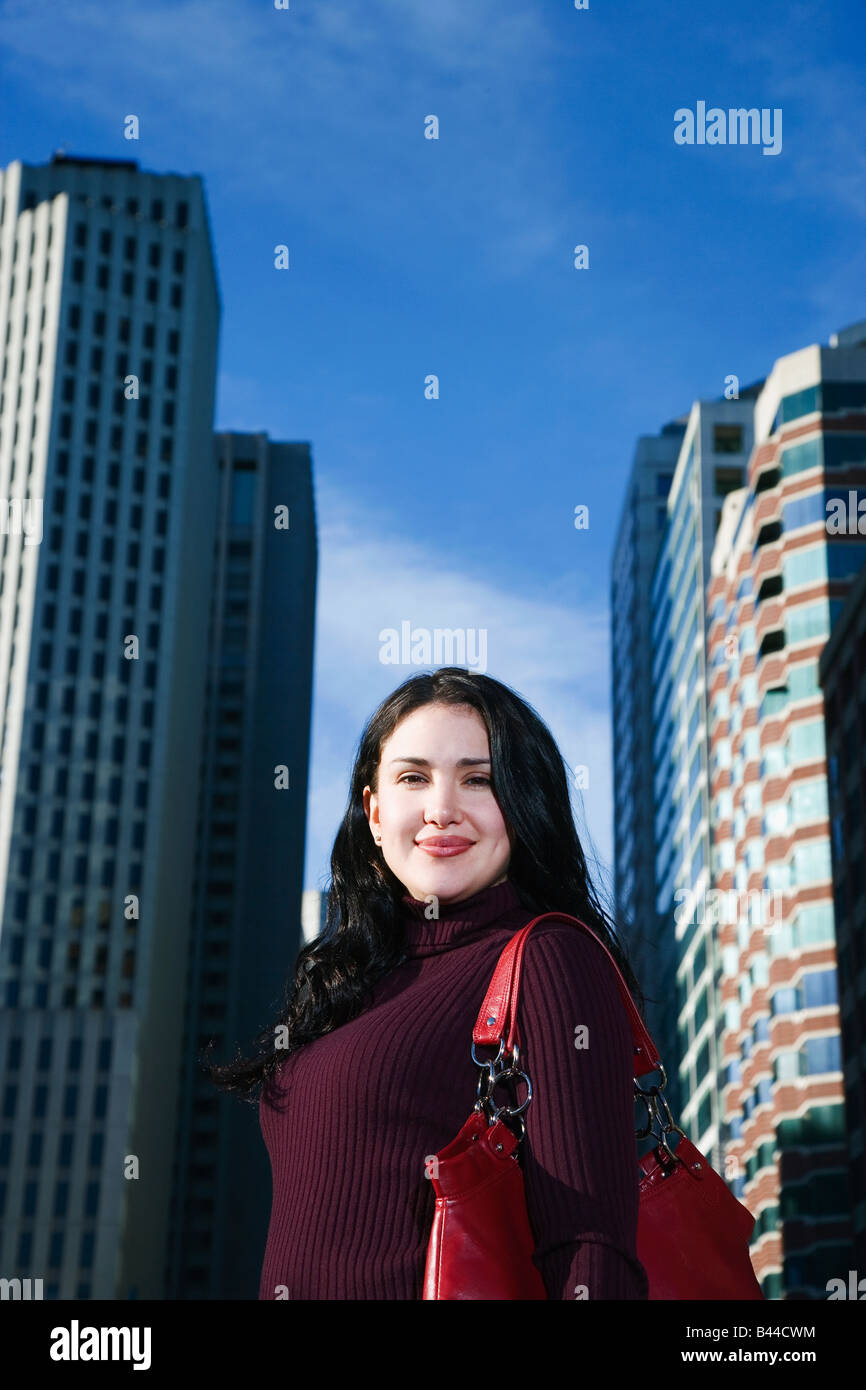 Hispanic woman in front of high-rises Stock Photo