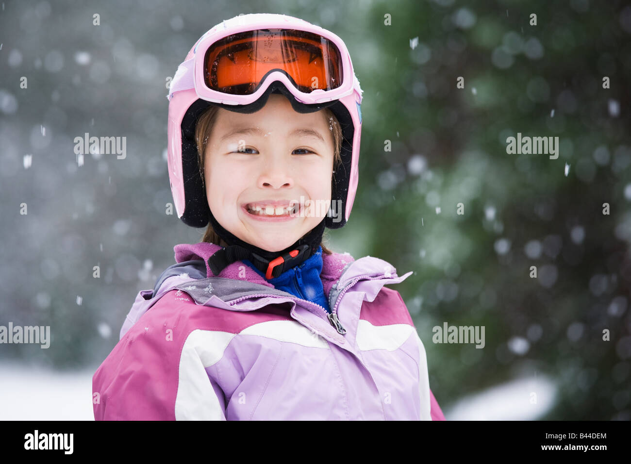 Asian girl wearing ski gear in snow Stock Photo