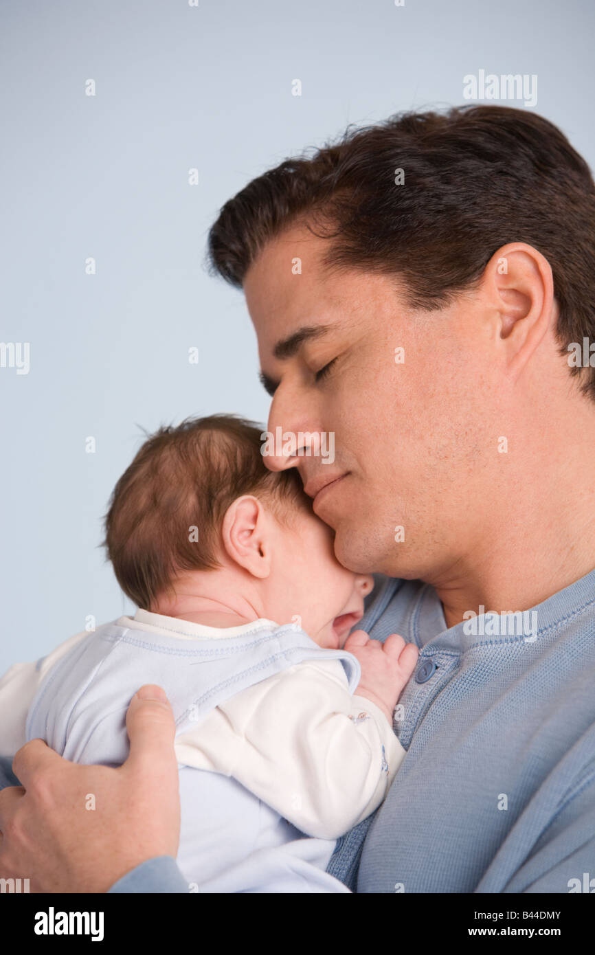 Hispanic father hugging baby Stock Photo
