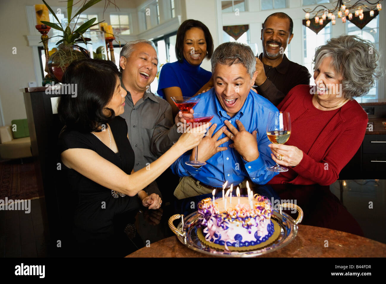 Hispanic man celebrating birthday with multi-ethnic friends Stock Photo