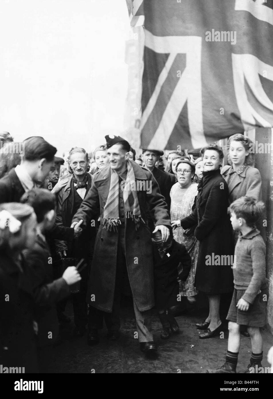 A repatriated British airman is welcomed home by friends and neighbours during WW2 1943 Stock Photo