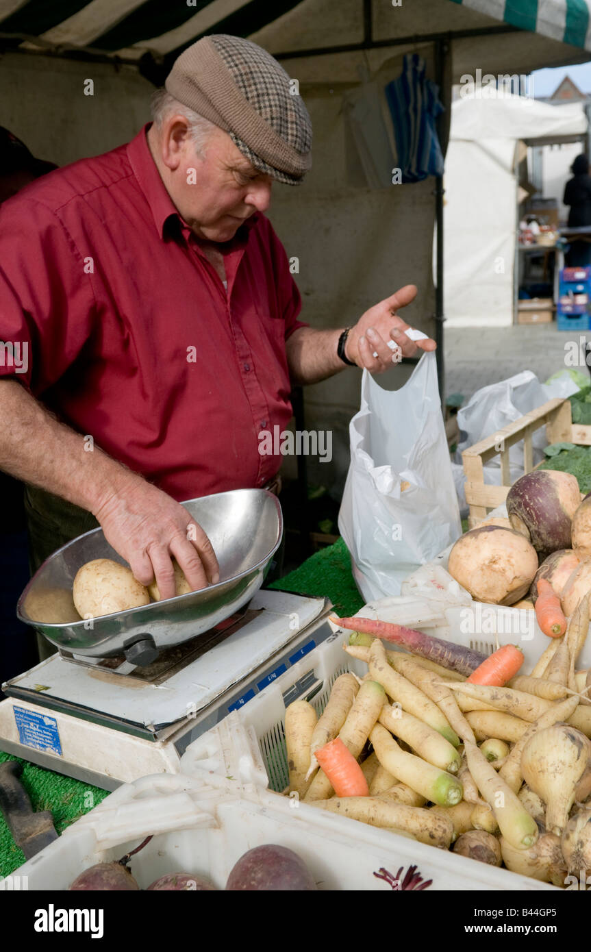 market trader weighing fresh local organic  potatoes at Aberystwyth farmers market and food fair Wales UK Stock Photo