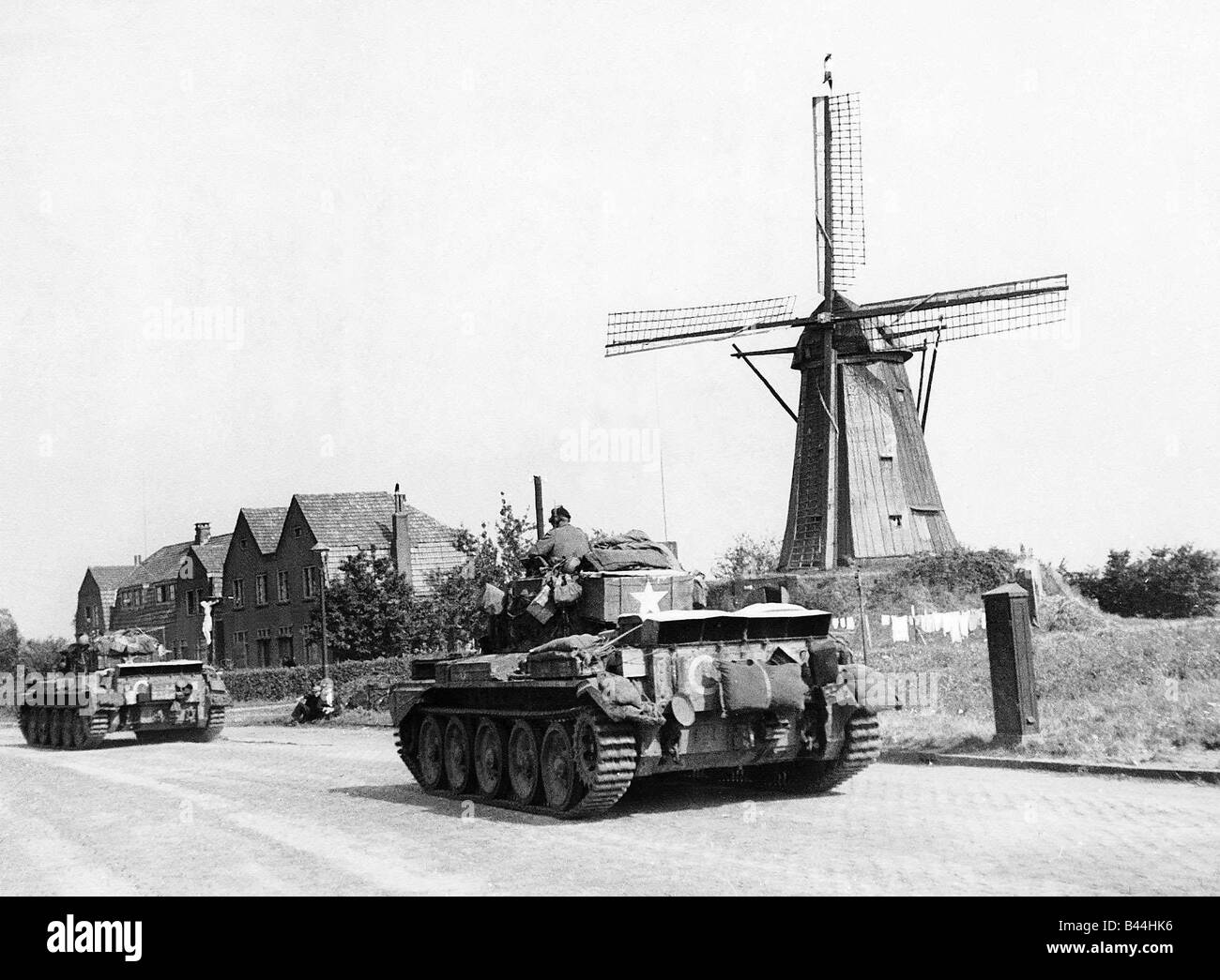 American army tanks pass a windmill in Holland on their way forward to the front line during WW2 1944 Stock Photo