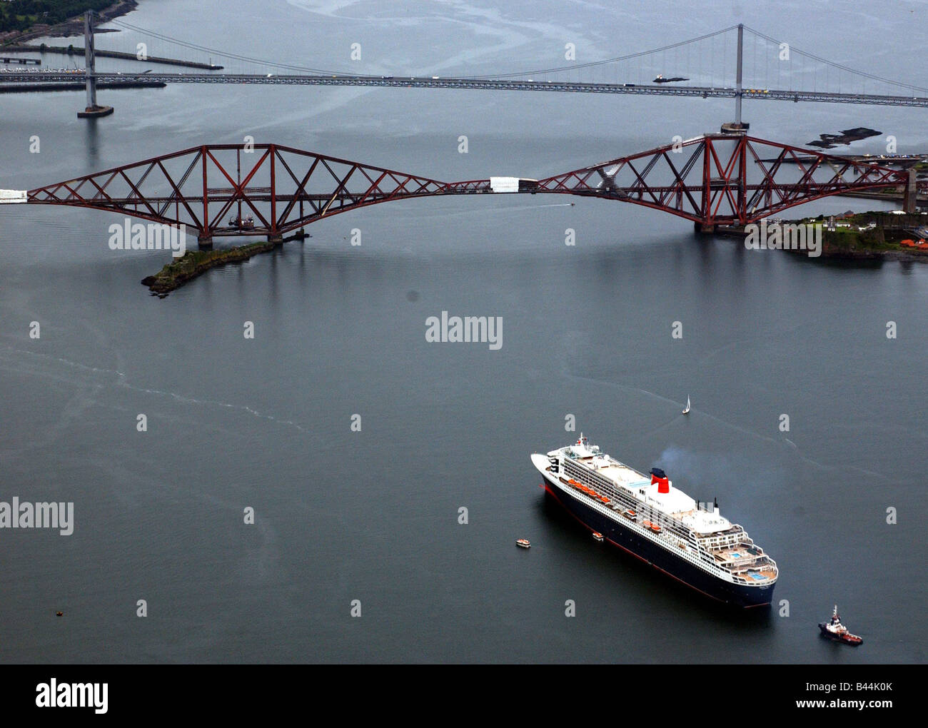 The Queen Mary II July 2004 paying her first visit to Scotland anchored in the Firth of Forth seen here about to pass under Stock Photo