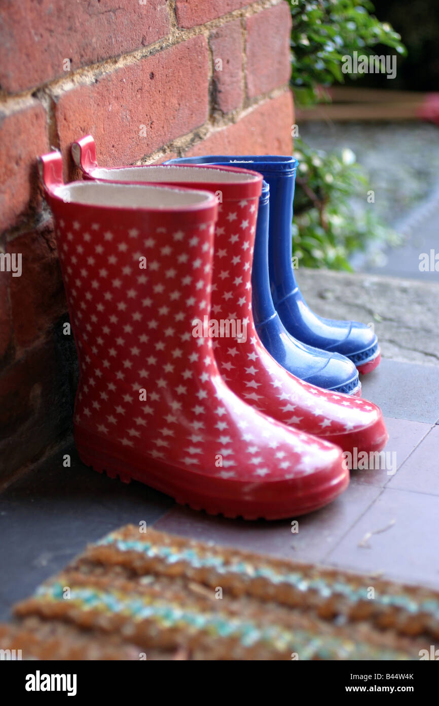 2 pairs of welly boots left on the doorstep Stock Photo