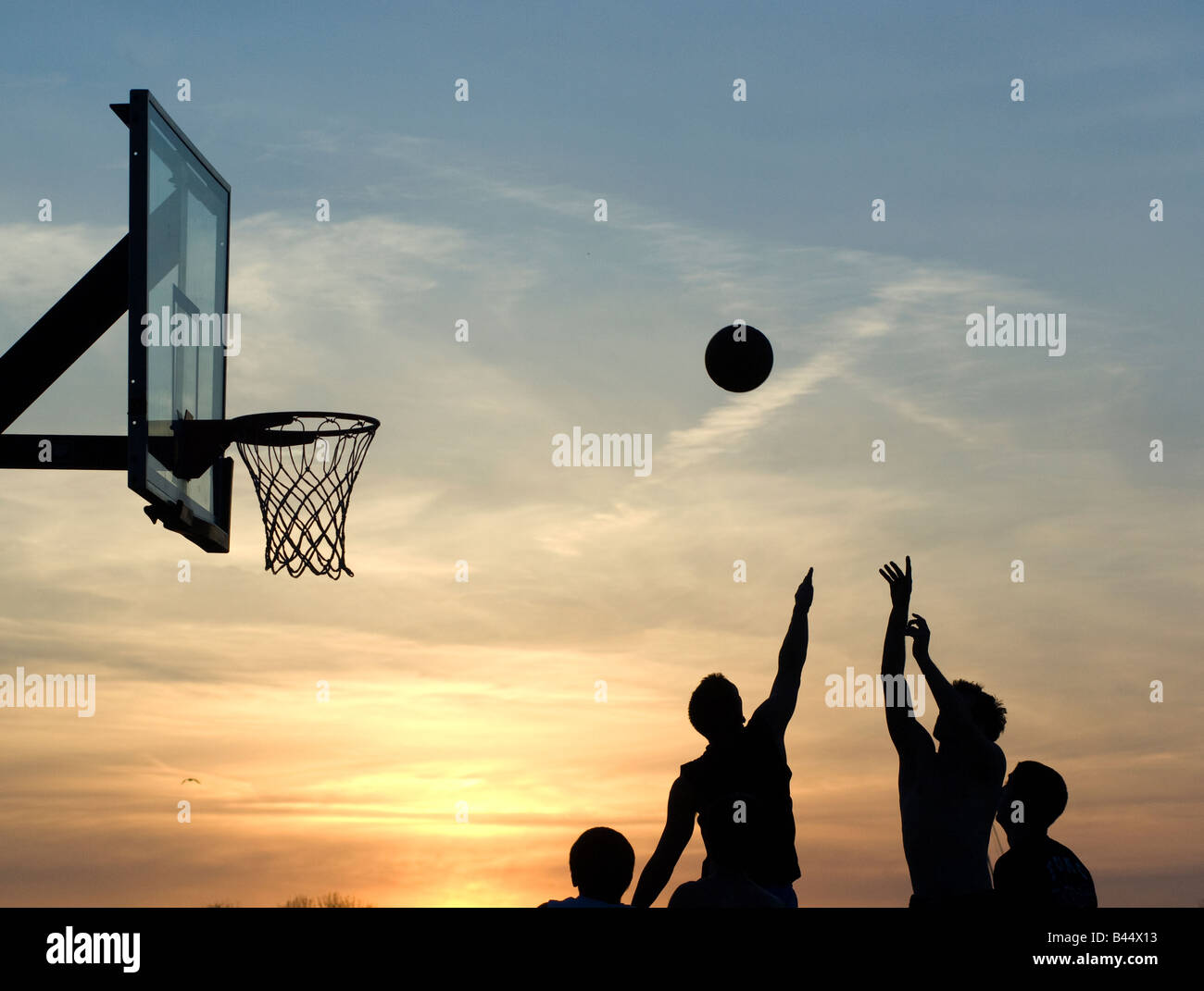 Basketball players shooting basket at sunset in outdoor park, Westport, Ct. Stock Photo