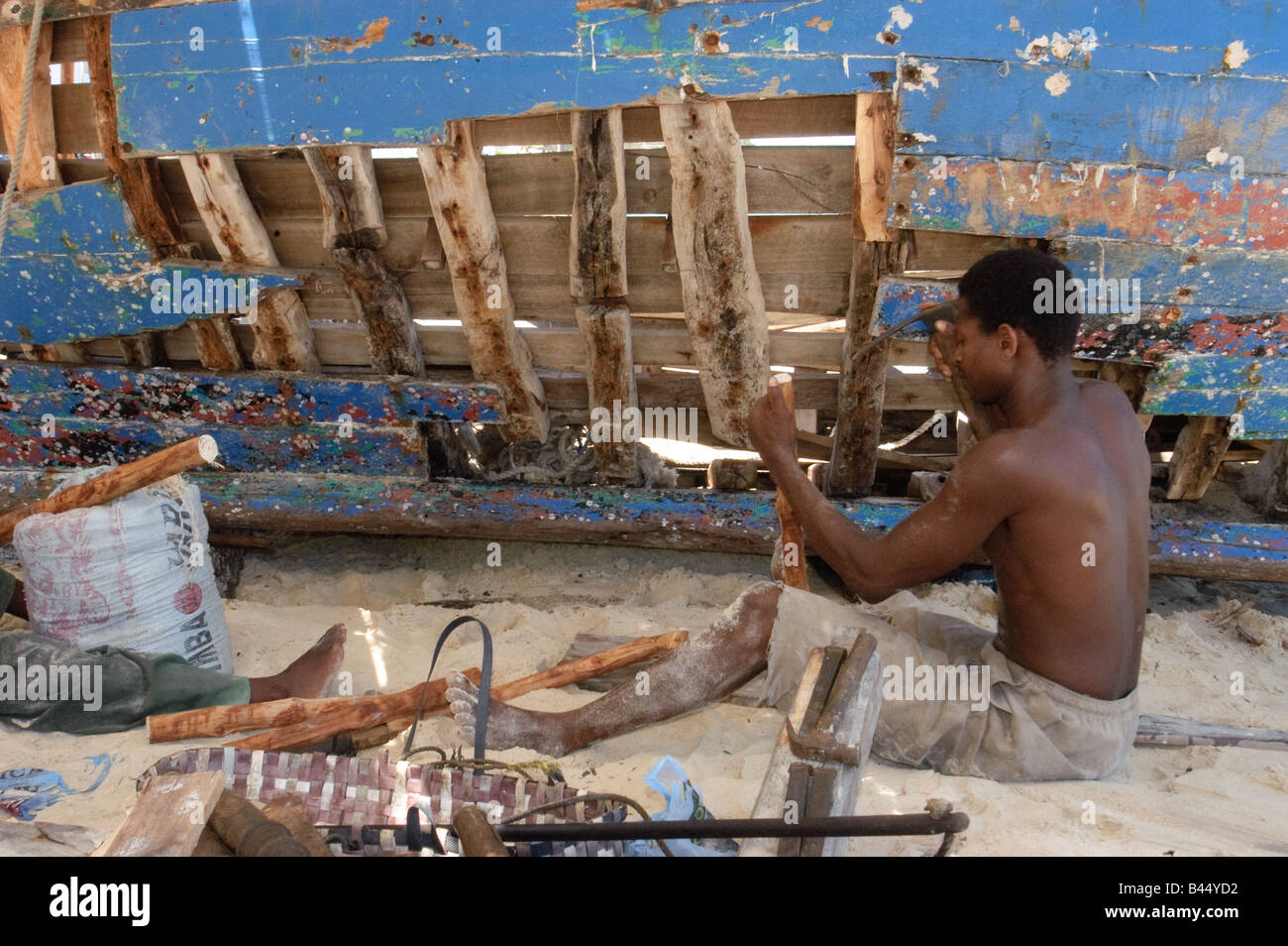 Skillful boatbuilder repairing a Dhow a traditional sailboat, Stone Town, Zanzibar, Tanzania Stock Photo