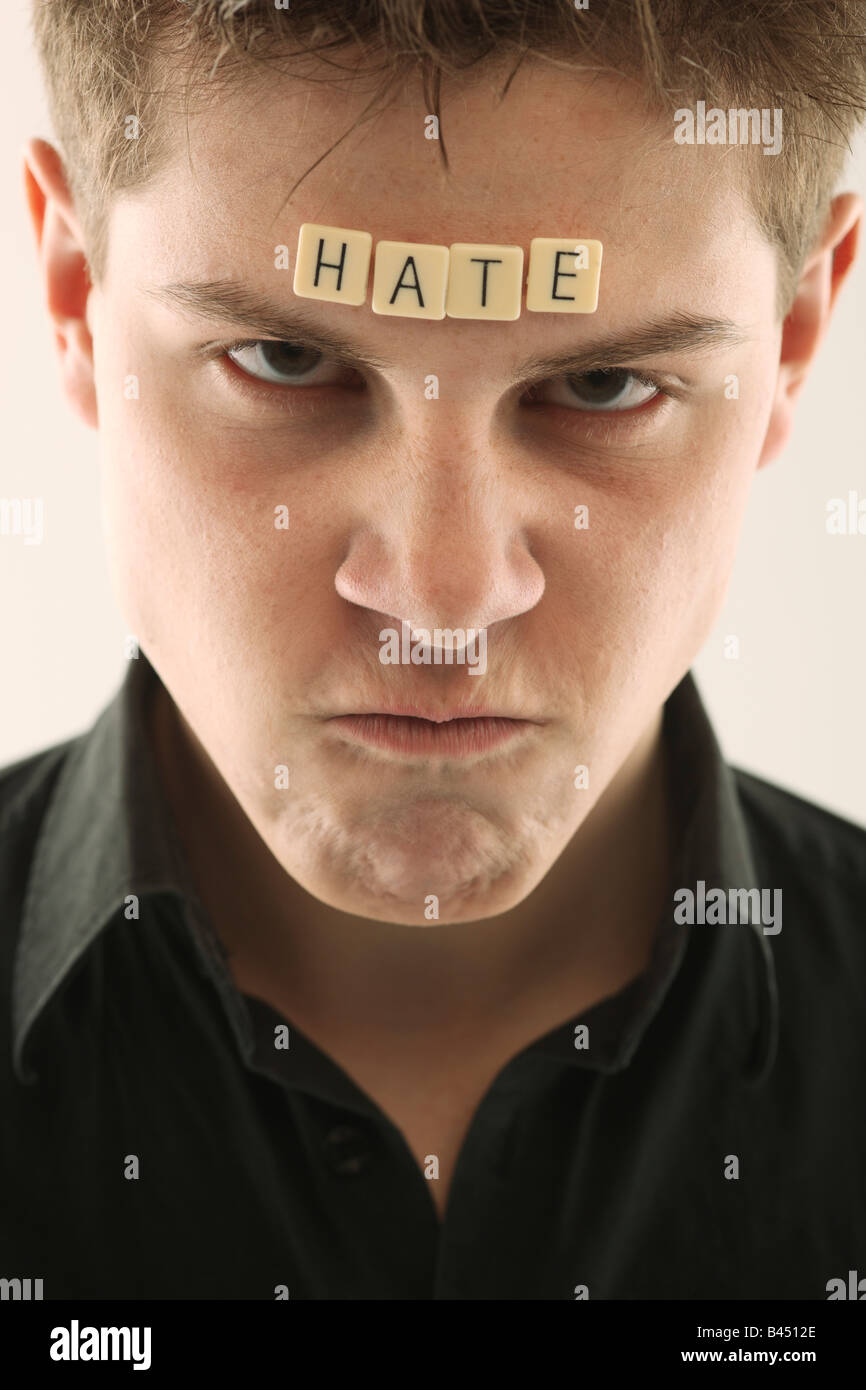 Man with the word 'hate' spelled with letter tiles on his head Stock Photo