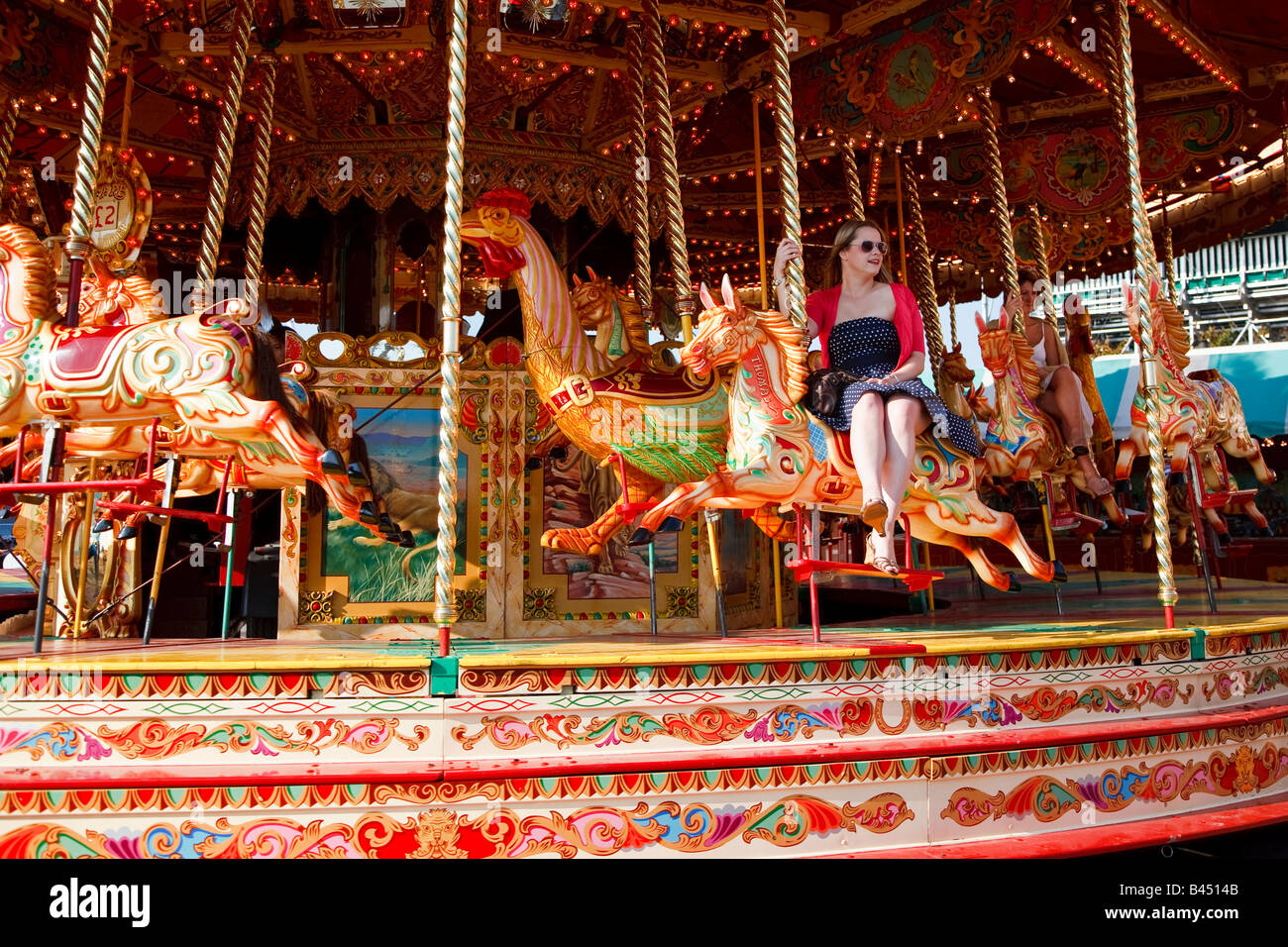 A young woman sitting side saddle on a horse on a carousel, Goodwood revival event West Sussex Great Britain UK  2008 Stock Photo