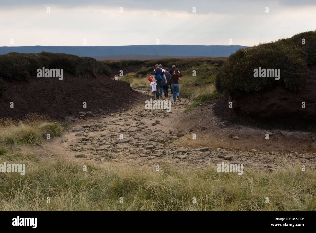 Walkers on Bleaklow walking through Peat Groughs Stock Photo