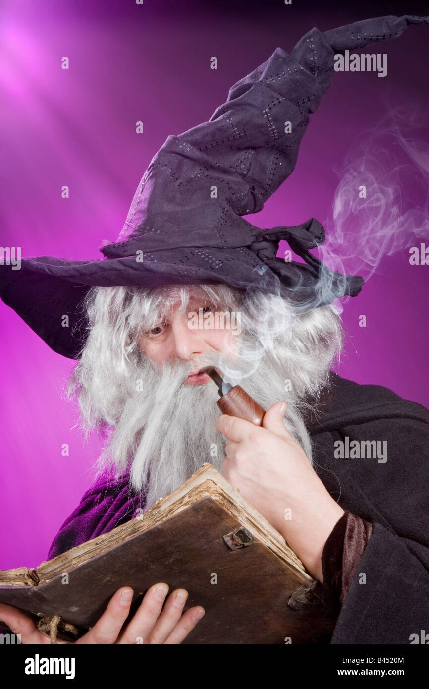 Evil sorcerer reading an ancient spell book Stock Photo