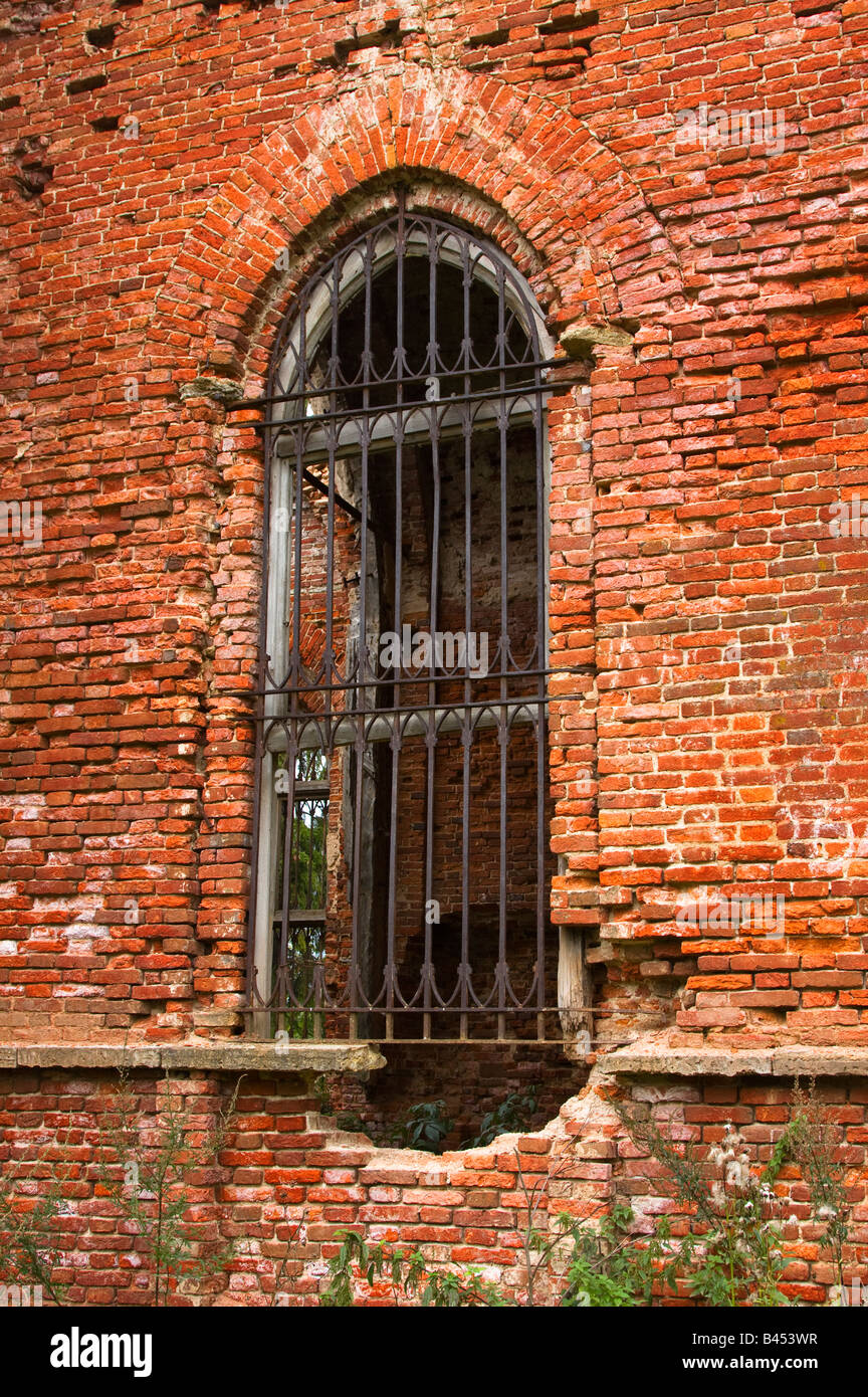 Ancient brick wall with window and iron lattice, St. Petersburg, Russia Stock Photo