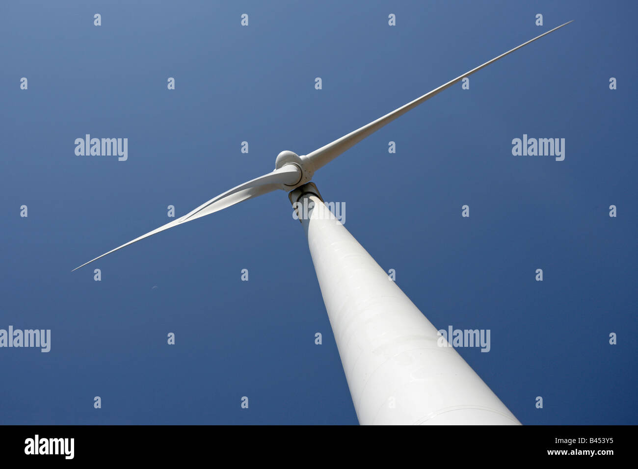 Wind powered electricity generating turbines up on towers in Europe This view is from directly underneath Stock Photo