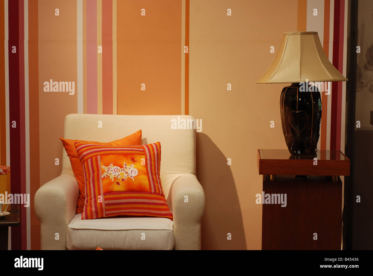 Armchair with cushions in living room Stock Photo - Alamy