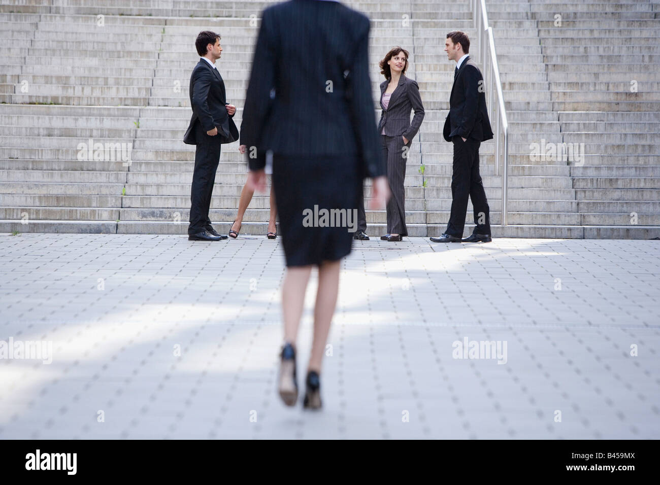 Germany, Baden-Württemberg, Stuttgart, Businesswoman walking, businesspeople in the foreground Stock Photo