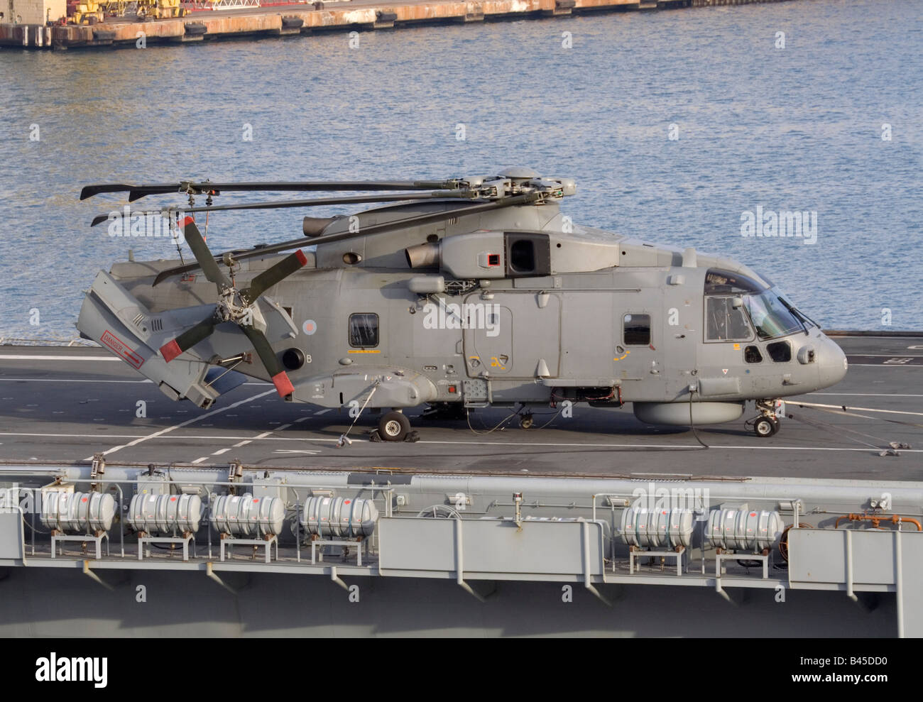 Royal Navy Merlin military helicopter with folded tail and rotor on the deck of HMS Illustrious Stock Photo