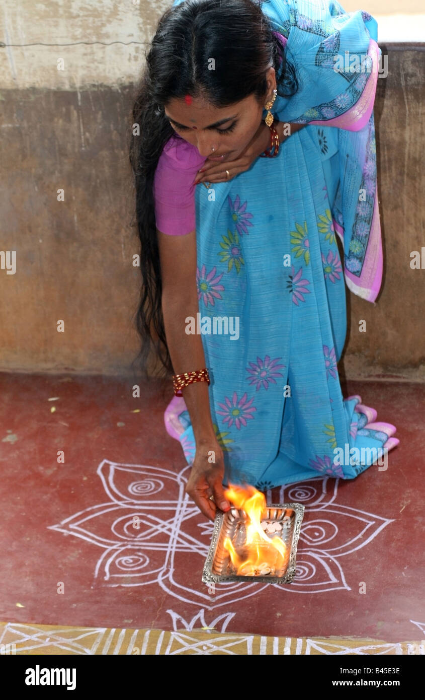 Indian lady blessing her home with arti fire pooja during Vishwakarma Ayudha Puja ceremony , India Stock Photo