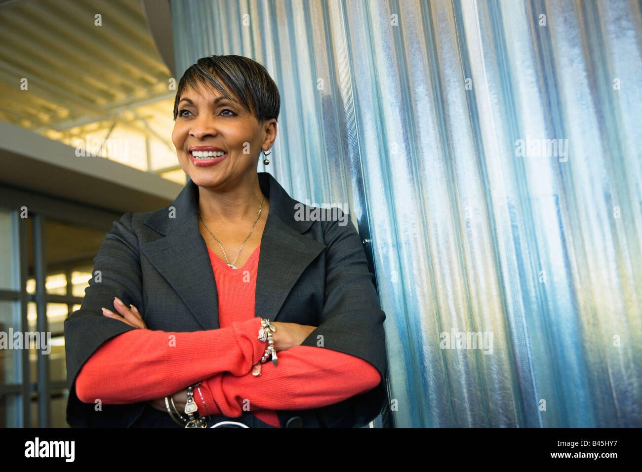 Smiling African businesswoman with arms crossed Stock Photo - Alamy