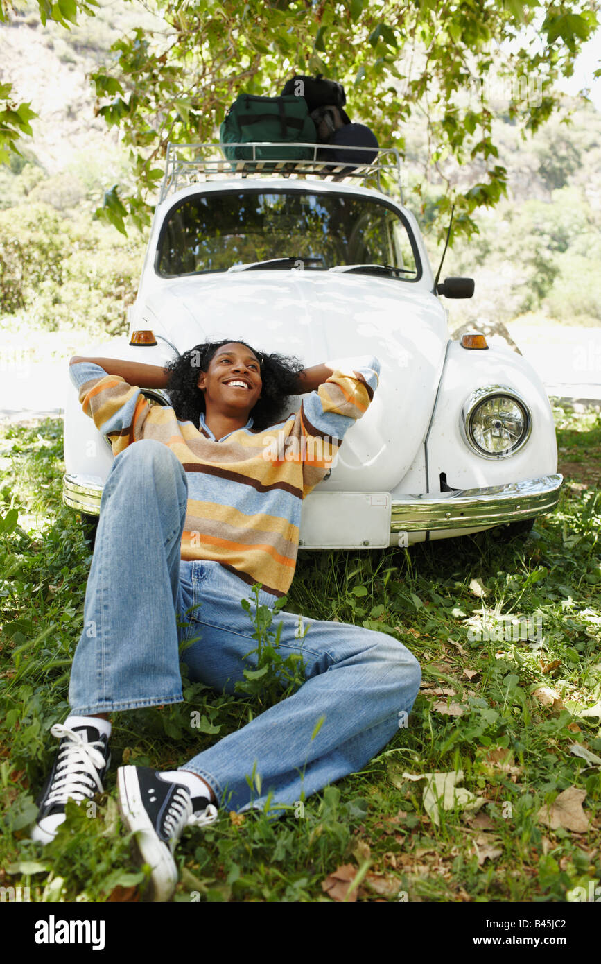 African man laying on hood of car Stock Photo Alamy