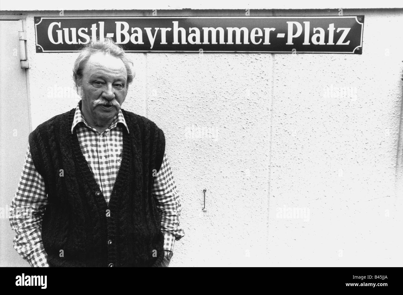Bayrhammer, Gustl, 12.2.1922 - 24.4.1993, German actor, half length, standing in front of road sign 'Gustl-Bayrhammer-Platz', late 1980s, Stock Photo