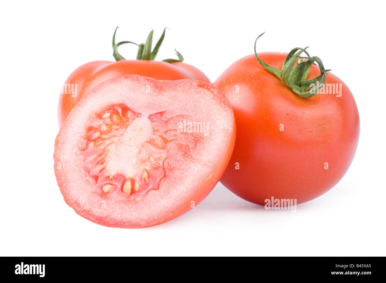 Ripe tomatoes isolated on a white background with one cut in half Stock Photo