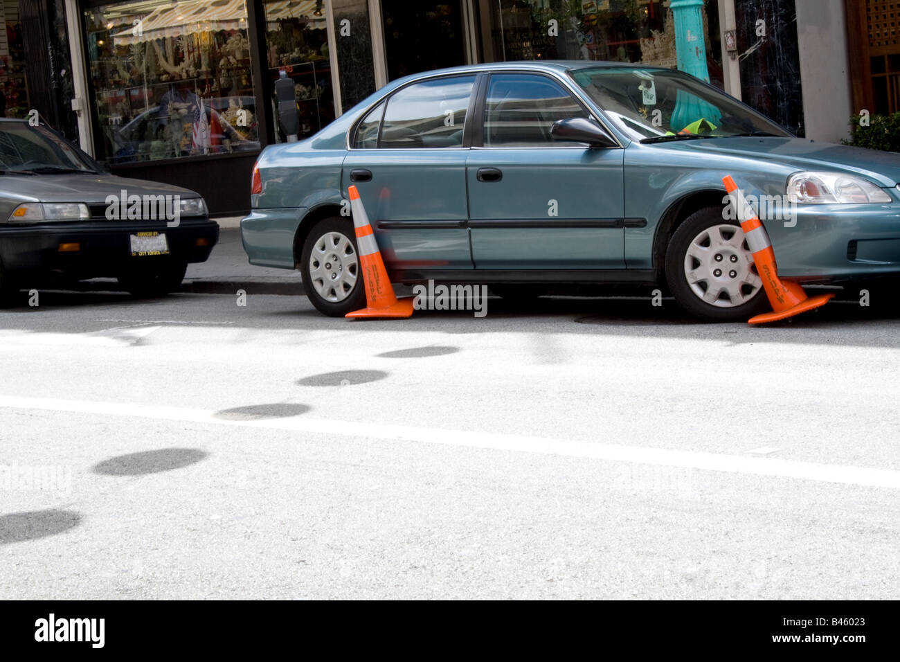 An automobile with orange cones entangled in the tires. Stock Photo
