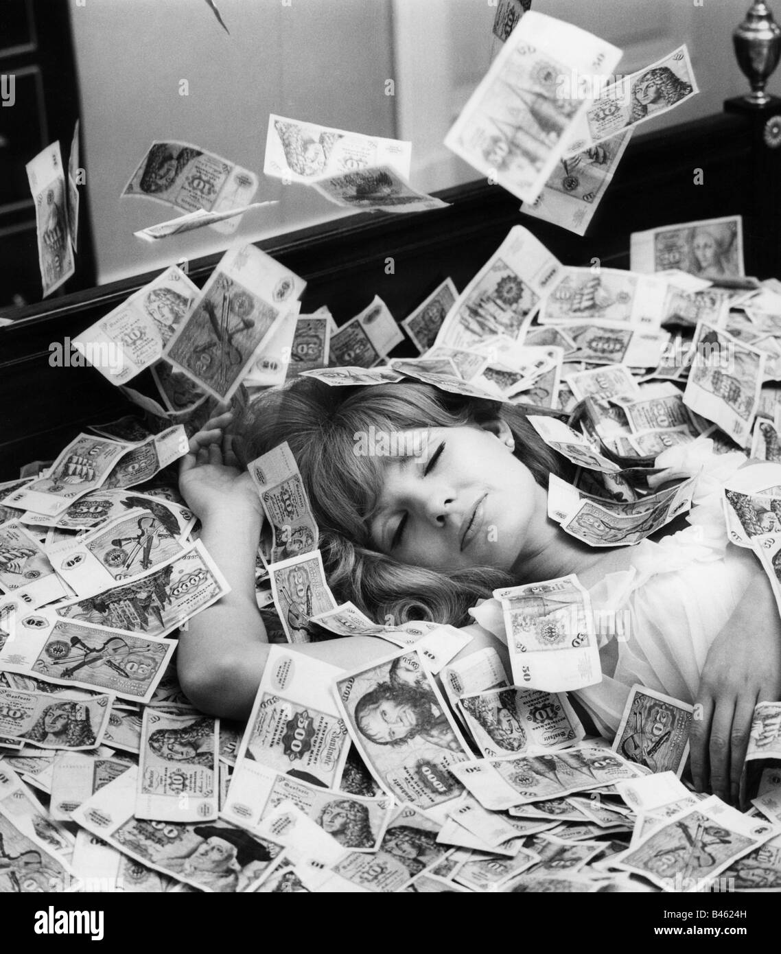 money / finance, bank notes, Germany, Deutsche Mark bank notes raining on lying woman, 1960s, Stock Photo