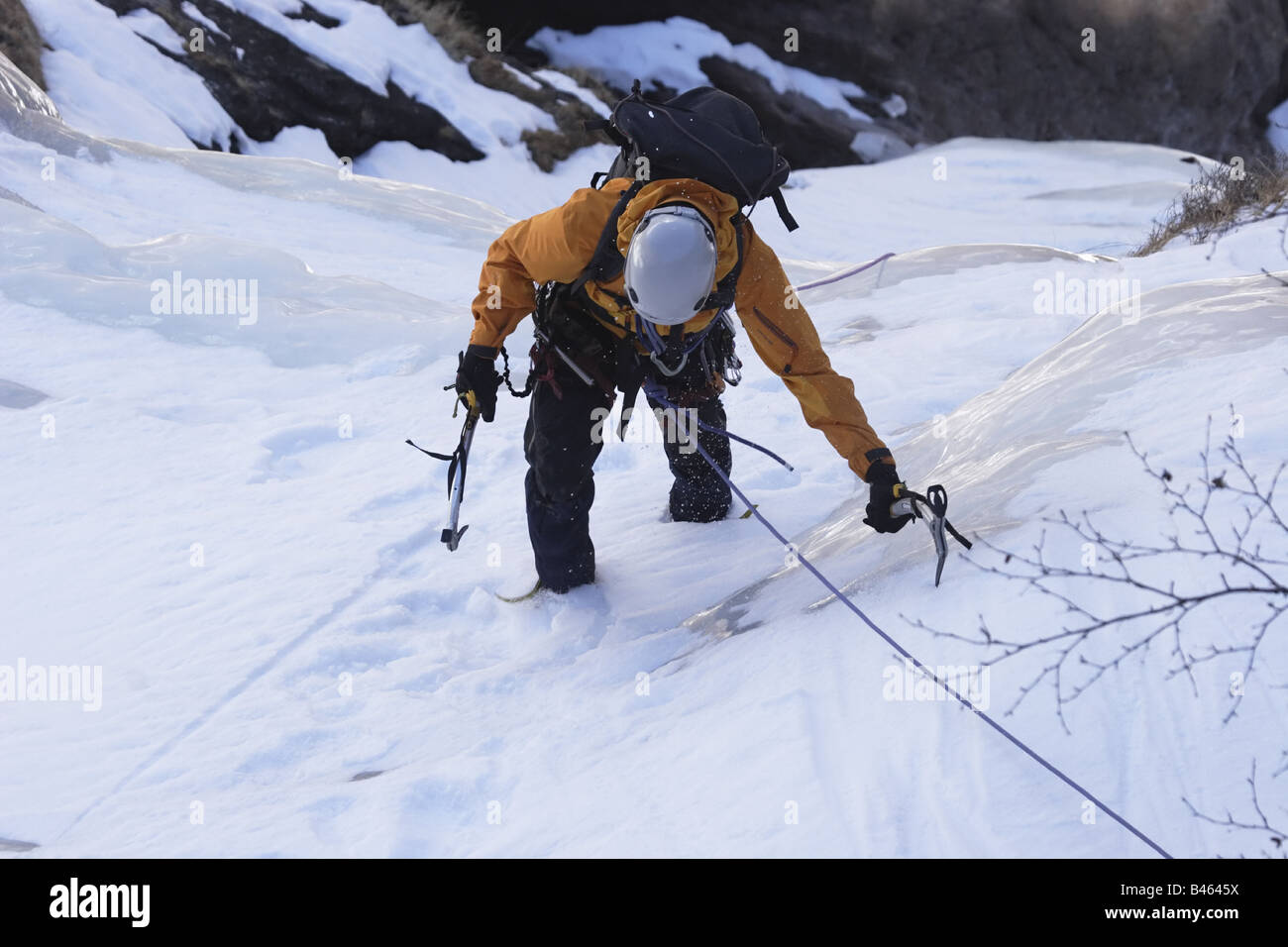 Ice climber making it up to a plateau in the Langtang Himalaya mountains, Nepal Stock Photo