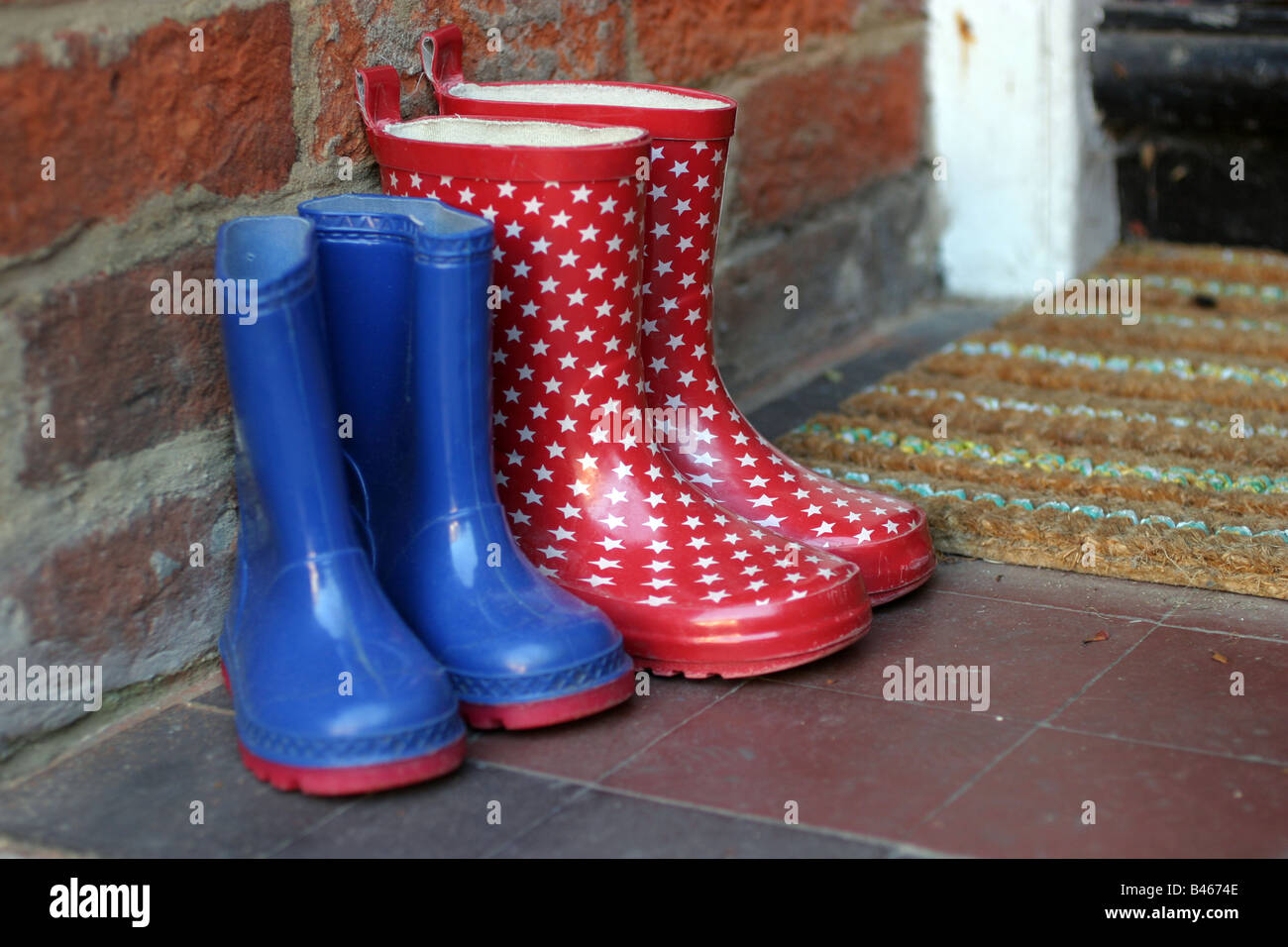 2 pairs of welly boots left on the doorstep Stock Photo