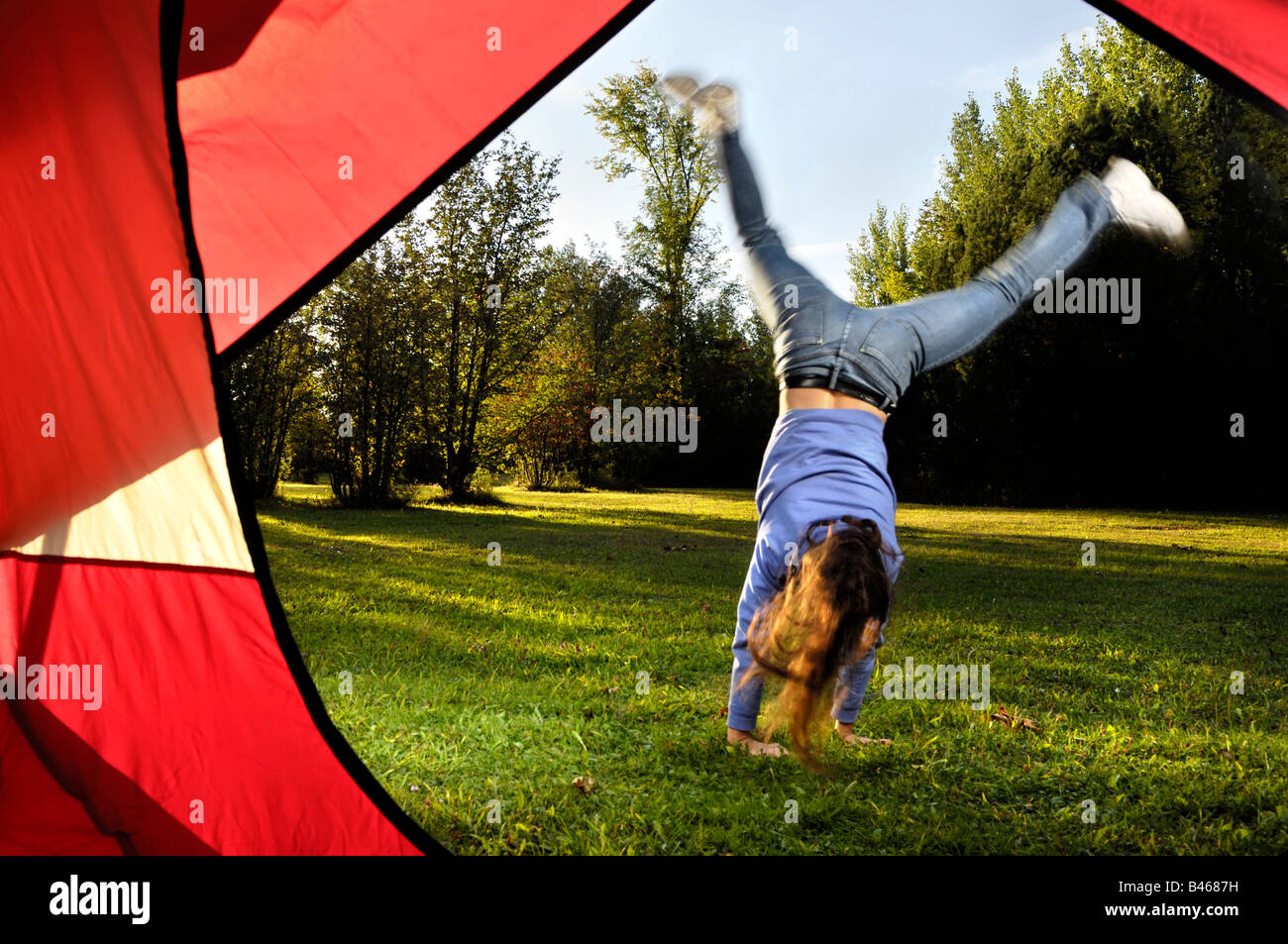 Young woman doing cartwheel Stock Photo