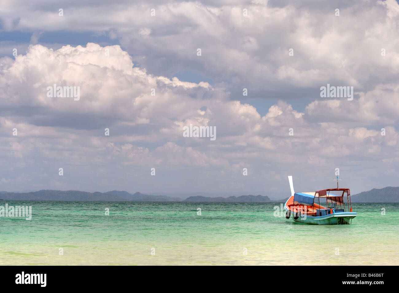 a boat on the colorful andaman sea with very cloudy sky, ko bulon